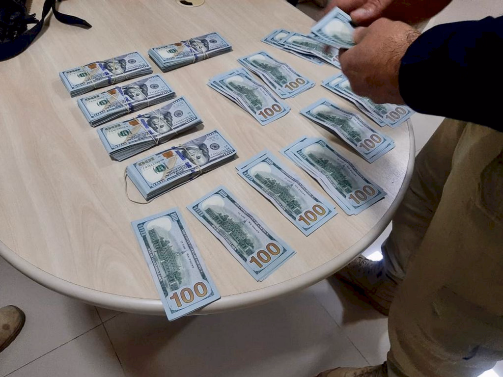 Mulher é pega com dólares escondidos debaixo da roupa