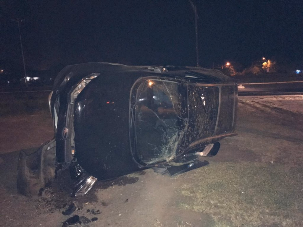 Comerciantes colidem com dois veículos estacionados e capotam